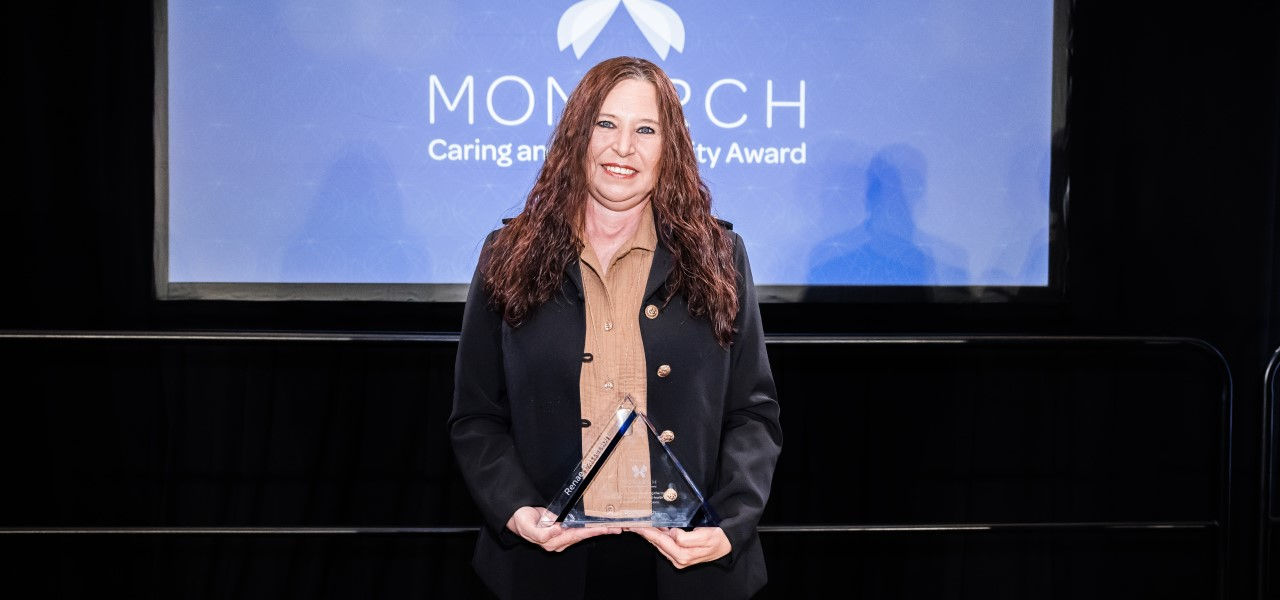 Renae Patterson poses with her Monarch Caring Award given to the best employees at ScionHealth